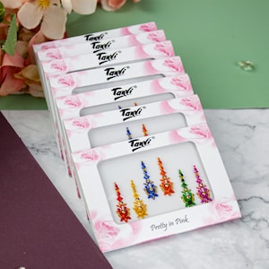 May include: Six packs of colourful temporary body jewellery, each pack contains five pieces of jewellery. The jewellery is in the shape of a teardrop and has a rainbow of colours. The packaging is white with pink flowers and the text "Pretty in Pink" on the bottom.