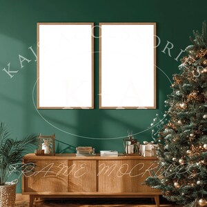 Peut inclure: Deux cadres avec des impressions d'art vierges sont accrochés à un mur vert foncé au-dessus d'un meuble en bois. Un sapin de Noël décoré se dresse à droite. La scène est une maquette pour afficher des œuvres d'art ou des photos.