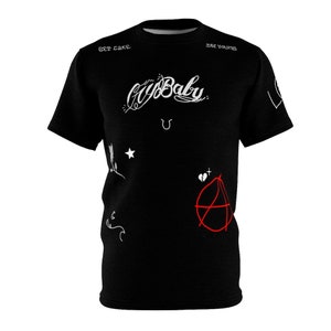 Puede incluir: Camiseta negra con texto blanco que dice "Cry Baby" y otros diseños gráficos blancos. El texto "Lil Cake" está en el hombro izquierdo y "Lil Young" está en el hombro derecho.