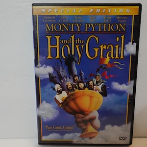 May include: DVD of the film "Monty Python and the Holy Grail." The cover features a blue background with the film's title in gold lettering. The image includes a castle, characters, and a golden chalice. The text "Pure Comic Genius" is also visible.