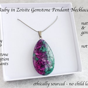 May include: A Ruby in Zoisite gemstone pendant necklace. The pendant is a large, teardrop-shaped stone with a mix of deep pink, green, and white colours. The necklace is presented in a white box. The text on the image says "natural & genuine, not dyed".