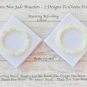 May include: Two jade bracelets with light green beads and silver spacer beads are displayed on white square platforms. The text on the image reads "Rare New Jade Bracelets - 2 Designs To Choose From" and "Stunning Refreshing Colour".