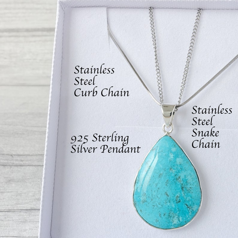 Op de afbeelding: Een turquoise druppelvormige hangerketting met een 925 sterling zilveren zetting. De hanger hangt aan een roestvrijstalen slangenketting. De ketting wordt gepresenteerd in een witte doos. Tekst: RVS Curb Chain, 925 Sterling Zilveren Hanger, RVS Snake Chain.
