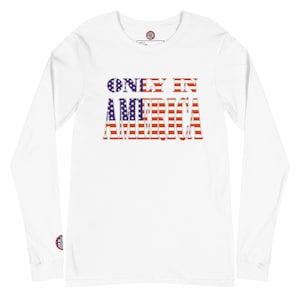 Puede incluir: Camiseta blanca de manga larga con el texto "ONLY IN AMERICA" en un diseño patriótico. El texto está relleno con el patrón de la bandera estadounidense de rayas rojas y blancas y estrellas azules.