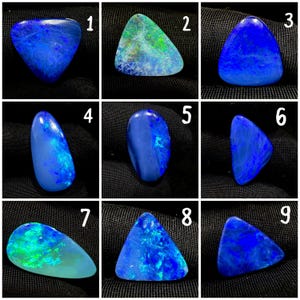 May include: A collection of nine polished loose opals labeled one through nine. Each gemstone displays vibrant blue and green iridescent flashes against a dark base. The stones vary in shape, including triangular, oval, and teardrop silhouettes.