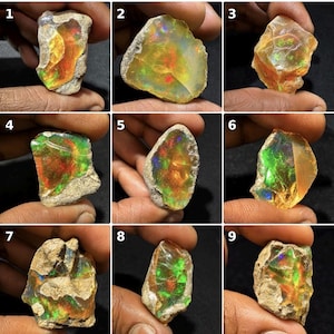 May include: A collection of nine raw, uncut opal gemstones, each displaying a unique play of color with vibrant flashes of red, green, and blue against a translucent to opaque base. The stones feature irregular, natural shapes and rough textures.