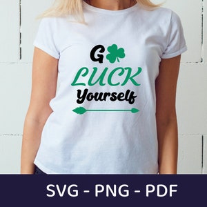 May include: White t-shirt with the text "Go Luck Yourself" in black and green, featuring a shamrock and arrow design. The shirt is a crew neck and is being worn by a person. The bottom of the image shows the text "SVG - PNG - PDF".