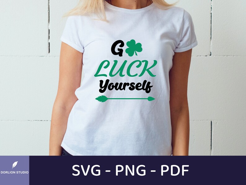 May include: White t-shirt with the text "Go Luck Yourself" in black and green, featuring a shamrock and arrow design. The shirt is a crew neck and is being worn by a person. The bottom of the image shows the text "SVG - PNG - PDF".