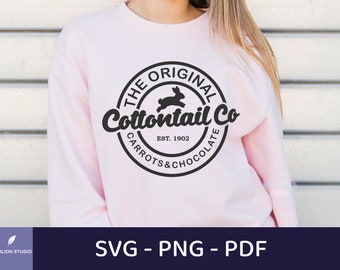 May include: A pink sweatshirt with a black and white logo that says "The Original Cottontail Co. Est. 1902 Carrots & Chocolate". The logo features a stylized rabbit silhouette.