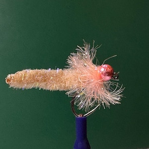May include: A pink and brown fly fishing lure with a fluffy tail and a bead head.