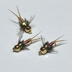 May include: Three gold-coloured fly fishing lures with brown and green feathers and a copper wire body.
