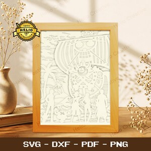 May include: A light wood-framed paper cut art piece featuring a layered white scene of a ship with a skull emblem, palm trees, and four figures standing on a beach. The artwork includes the text Lightbox HELIO CREATIVE in the corner.