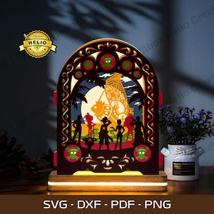 Pode incluir: Luz LED de madeira em camadas com uma cena de navio pirata e silhuetas de personagens. O design inclui um arco decorativo, palmeiras e o texto "SVG - DXF - PDF - PNG". A luz está sobre uma base de madeira.