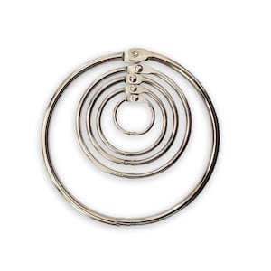 May include: A set of five silver-colored metal loose-leaf binder rings of varying sizes, nested concentrically. Each circular ring features a hinged locking mechanism at the top, allowing the rings to open and close securely for organizing papers.