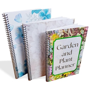 May include: Three spiral bound notebooks with floral designs. The front cover of the notebook on the right has the text "Garden and Plant Planner".