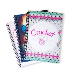 May include: Three spiral-bound notebooks with colorful covers. The front notebook features the word "Crochet" in pink, with a heart and yarn design. The covers display crochet patterns in white, pink, and teal. The notebooks are stacked on a white background.