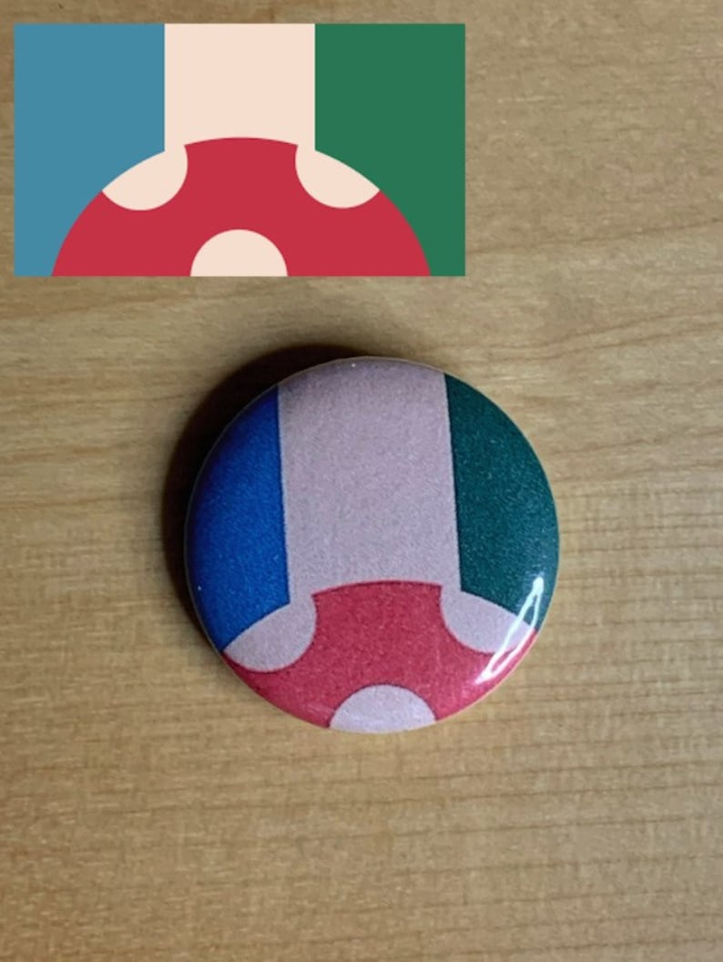 May include: A round button with a mushroom design. The mushroom is red with white spots and is on a background of blue, pink, and green.