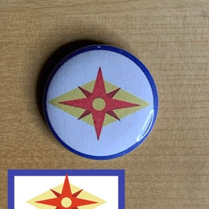 May include: A blue and white button with a red and yellow starburst design. The starburst has a yellow diamond shape with a red star in the center. The star has a yellow circle in the center.