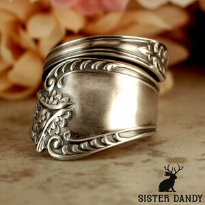 Puede incluir: Un anillo de plata hecho con una cuchara, con detalles florales y de volutas. El anillo, hecho de cubiertos reciclados, tiene una banda ancha. Una joya &uacute;nica.