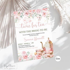 Puede incluir: Una invitación a una fiesta de té rosa y dorada con un diseño floral, una tetera, tazas de té y macarons. El texto dice "Time for Tea with the Bride-to-Be".