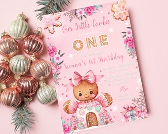 May include: A pink birthday invitation with a gingerbread theme. The invitation features a gingerbread girl, floral accents, and the text "Our Little Cookie is turning ONE." Decorative ornaments and greenery are arranged on a pink surface.