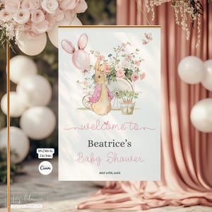 May include: A baby shower sign featuring a watercolor illustration of a bunny pushing a cart filled with flowers. The sign reads "welcome to Beatrice's Baby Shower" with the date. The sign is framed in gold and includes the dimensions 18x24in & 24x36in.