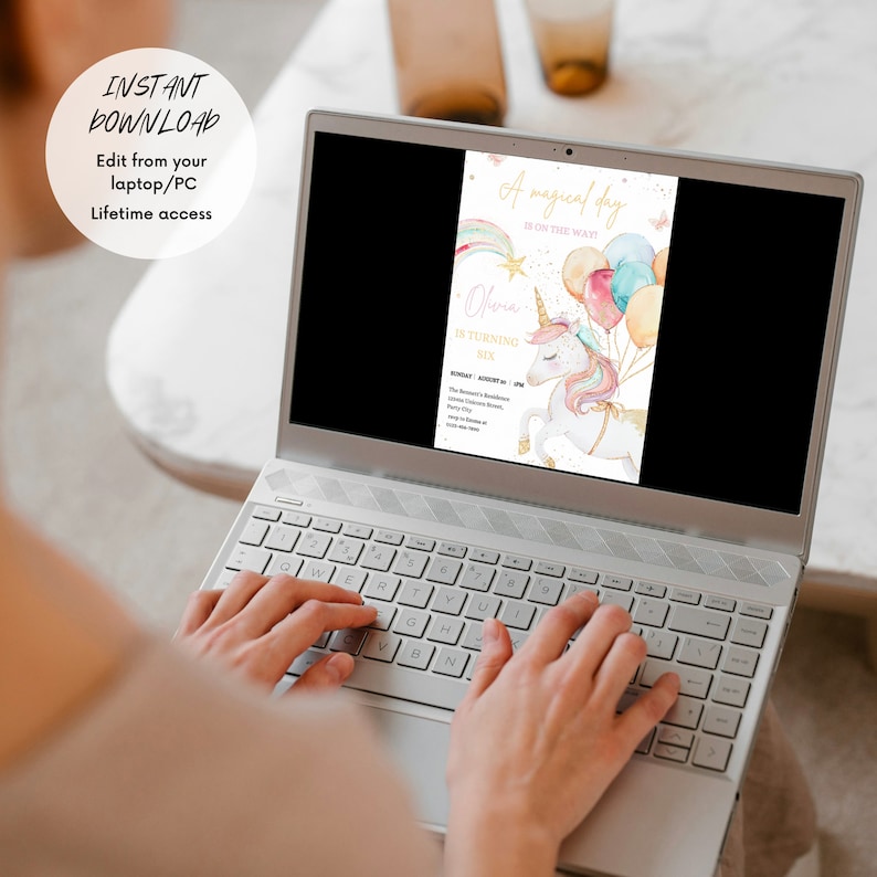 May include: A laptop screen displaying a digital invitation for a unicorn-themed birthday party. The invitation features a watercolor illustration of a unicorn with balloons and a rainbow. The text on the invitation reads "A magical day is on the way!" and "Olivia is turning six".