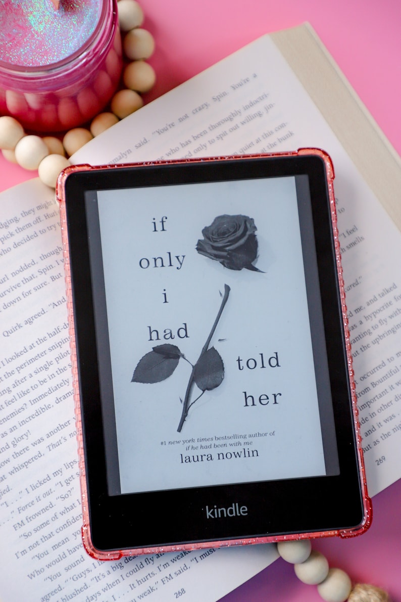 May include: A pink Kindle e-reader with a glittery pink case displaying the cover of the book "If Only I Had Told Her" by Laura Nowlin. The book cover features a black and white illustration of a rose.