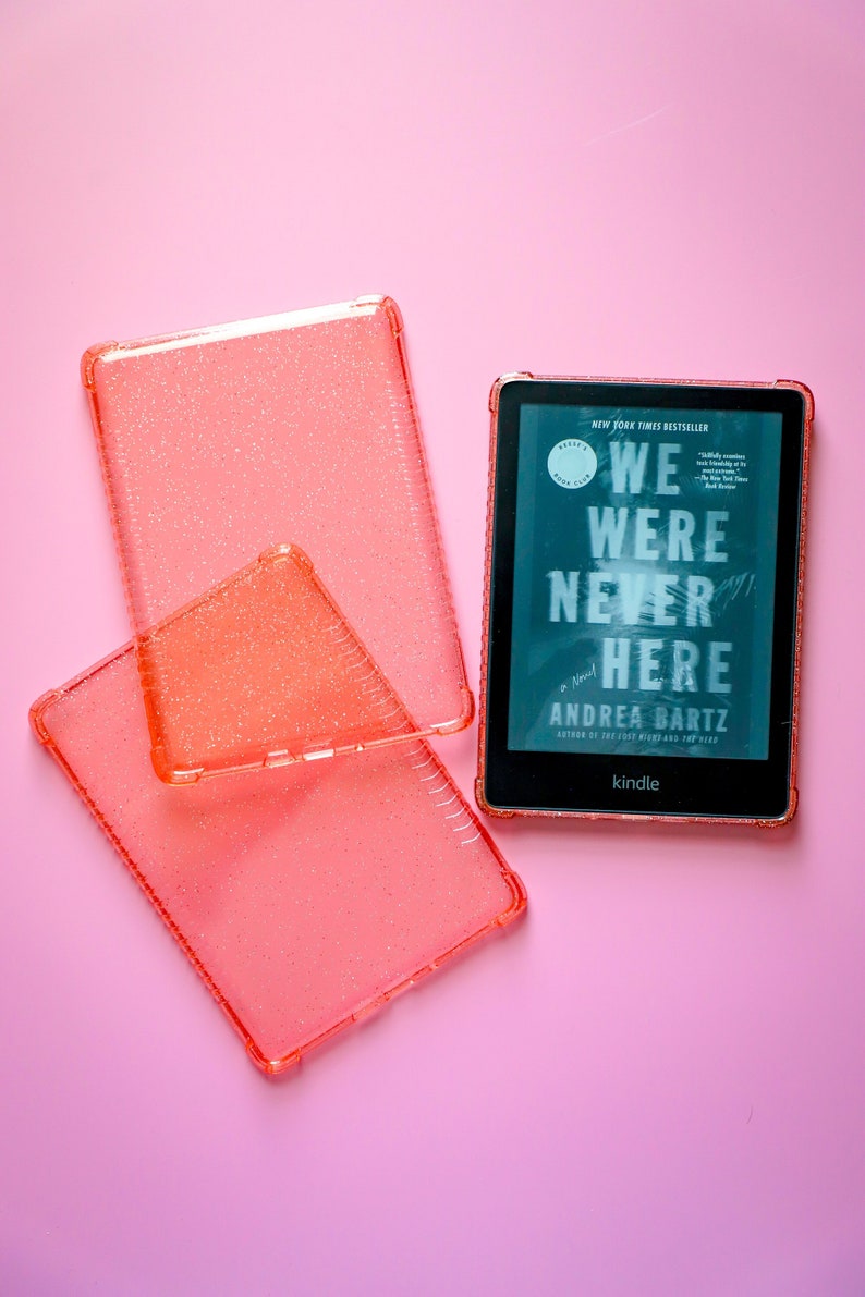 May include: A pink glitter Kindle e-reader case with the book "We Were Never Here" by Andrea Bartz displayed on the screen.