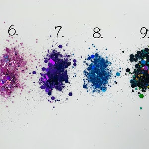 K&ouml;nnte beinhalten: Vier Glitterproben in verschiedenen Farben: rosa, lila, blau und schwarz mit gr&uuml;nen und blauen Akzenten. Die Proben sind mit 6, 7, 8 und 9 beschriftet.