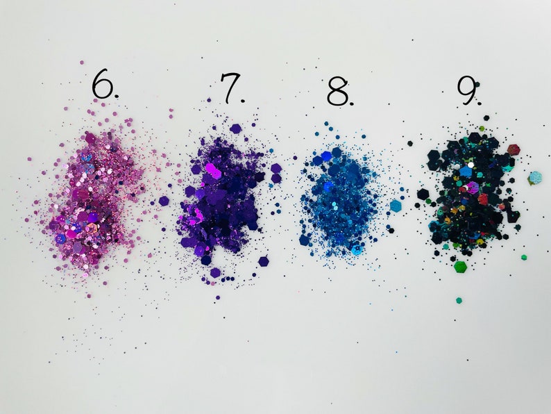 K&ouml;nnte beinhalten: Vier Glitterproben in verschiedenen Farben: rosa, lila, blau und schwarz mit gr&uuml;nen und blauen Akzenten. Die Proben sind mit 6, 7, 8 und 9 beschriftet.