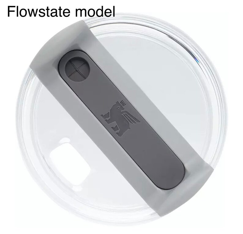 K&ouml;nnte beinhalten: Ein durchsichtiger Plastikdeckel mit einem grauen Druckknopfdeckel. Der Deckel hat ein Logo mit einem gefl&uuml;gelten L&ouml;wen mit einer Krone auf dem Kopf.