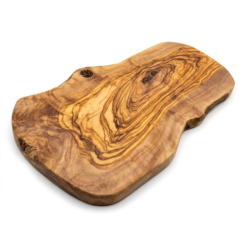May include: A natural-edged olive wood cutting board with a prominent, swirling grain pattern in shades of light and dark brown. The board features an irregular, organic shape and includes the brand name OLIVIKO branded into the top left corner.