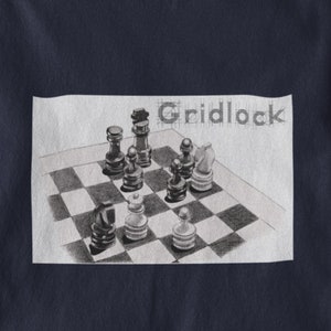 Puede incluir: Una camiseta azul marino con un dibujo de un tablero de ajedrez con piezas de ajedrez sobre él. El texto "Gridlock" está escrito sobre el tablero de ajedrez.