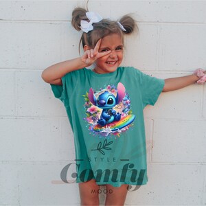 a little girl wearing a t - shirt with an image of stitching stitching