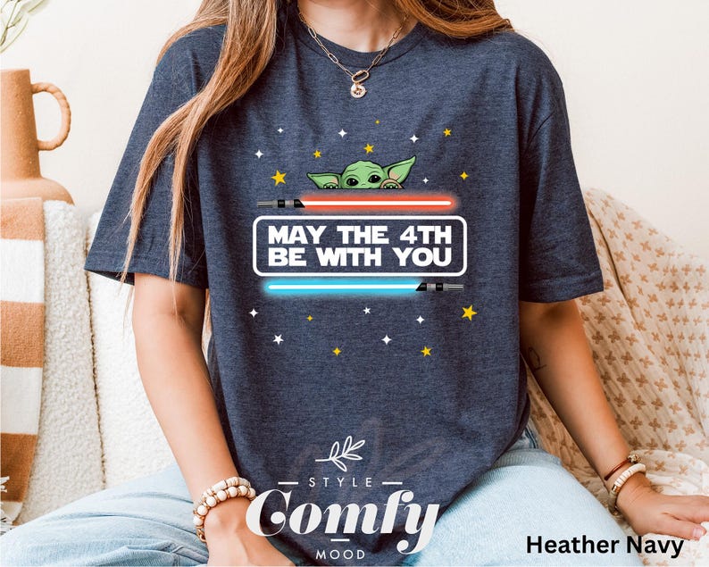 K&ouml;nnte beinhalten: Ein heidefarbenes marineblaues T-Shirt mit einem Aufdruck eines gr&uuml;nen Au&szlig;erirdischen mit dem Text "May the 4th Be With You".