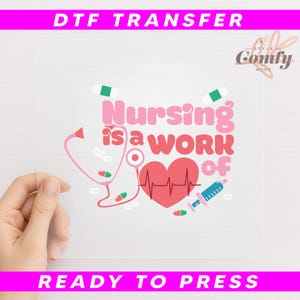 May include: A clear DTF transfer sheet with the text "Nursing is a work of" in pink, along with a stethoscope, heart, and syringe graphic. The words "DTF TRANSFER" and "READY TO PRESS" are in pink banners.