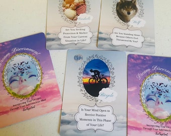 May include: A set of 5 oracle cards with colourful backgrounds and illustrations. The cards feature images of seashells, a wolf, a bicycle, and a woman's face with birds flying out of her eyes. The cards have text on them, including the words "Dream Discernment", "Seashells", "Wolf", "Bicycle", and "Is Your Mind Open to Receive Positive Moments in This Phase of Your Life?"