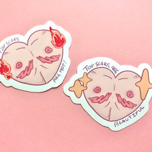 May include: Two heart-shaped stickers with a pink and white illustration of a chest with scars. The top sticker says "Top Scars Are Hot!" and the bottom sticker says "Top Scars Are Beautiful".