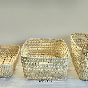 Puede incluir: Tres cestas tejidas de diferentes tama&ntilde;os. Las cestas est&aacute;n hechas de materiales naturales y tienen un color beige claro. Las cestas est&aacute;n etiquetadas con sus dimensiones: 45/35/10, 45/30/17 y 45/25/25.