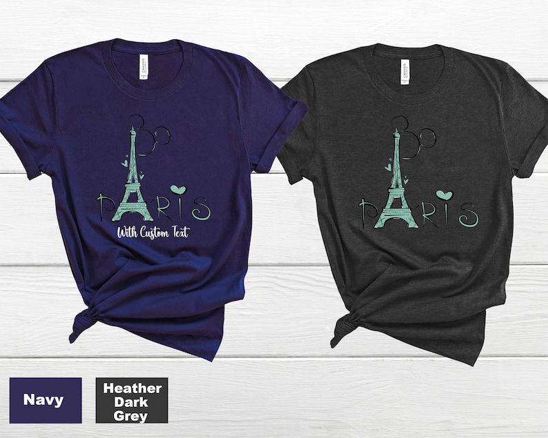 Op de afbeelding: Twee t-shirts, marineblauw en donkergrijs gem&ecirc;leerd, met een turquoise Eiffeltoren ontwerp, het woord "PARIS" en de tekst "With Custom Text". De shirts zijn gemaakt van zacht materiaal.