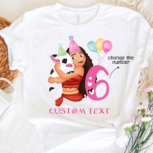 Pu&ograve; includere: Maglietta bianca con un numero 6 rosa, un maiale dei cartoni animati e una ragazza con i capelli castani. Il testo "change the number" e "CUSTOM TEXT" &egrave; anche sulla maglietta.