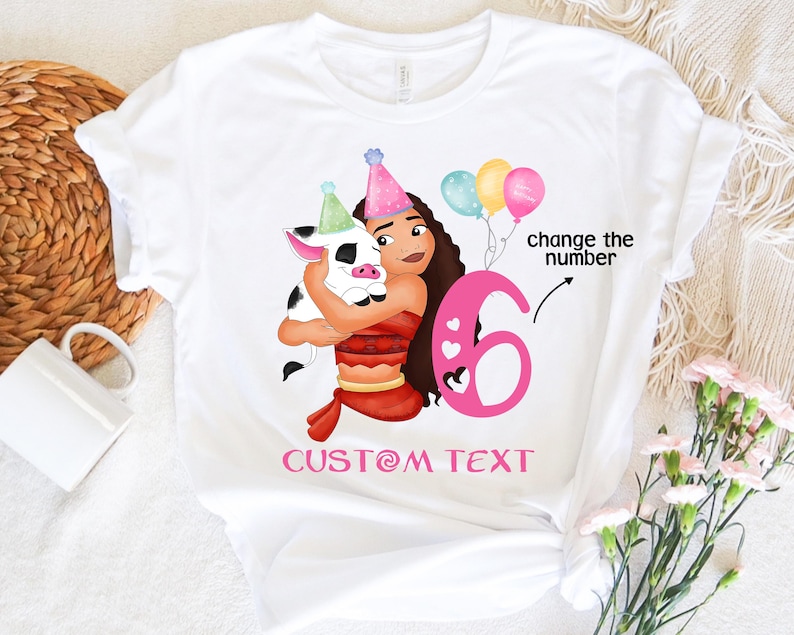 Pu&ograve; includere: Maglietta bianca con un numero 6 rosa, un maiale dei cartoni animati e una ragazza con i capelli castani. Il testo "change the number" e "CUSTOM TEXT" &egrave; anche sulla maglietta.