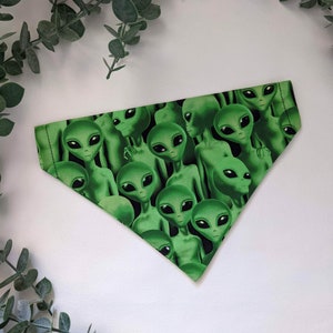 Könnte beinhalten: Grünes dreieckiges Bandana mit einem Muster aus sich wiederholenden Alien-Gesichtern.