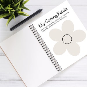 May include: A white notebook with a spiral binding. The front cover has a black and white flower with the text "My Coping Petals" and instructions to write your name in the middle of the flower and coping skills on each petal.