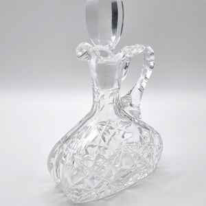 May include: A clear glass oil and vinegar bottle with a diamond pattern and a clear glass stopper.
