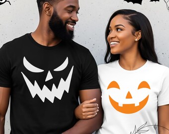 May include: Two people wearing Halloween-themed t-shirts. One shirt is black with a white jack-o'-lantern face design. The other is white with an orange jack-o'-lantern face design. The background has Halloween decorations.