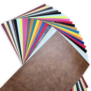 May include: A fan of colorful vinyl sheets in various shades of red, orange, yellow, green, blue, purple, pink, brown, black, white, and gray. The sheets are arranged in a fan shape, with the brown sheet at the bottom.