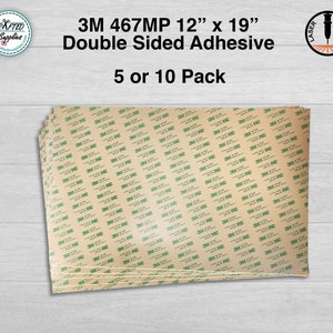 May include: A stack of 3M 467MP double-sided adhesive sheets in a brown color with green 3M branding. The sheets are 12 inches by 19 inches and are available in packs of 5 or 10.