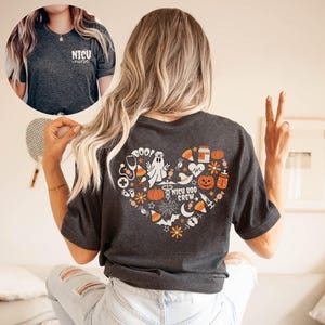 May include: Dark gray t-shirt with a heart-shaped Halloween design on the back, featuring a ghost, pumpkins, and the words "NICU BOO CREW." The front of the shirt has the words "NICU nurse."
